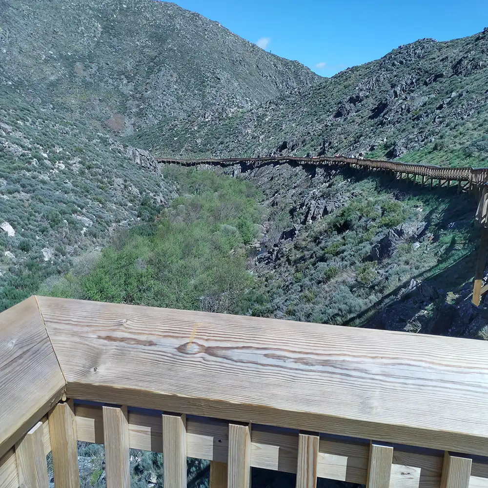 Un puente de madera serpentea por un valle verde en la Serra da Estrela.