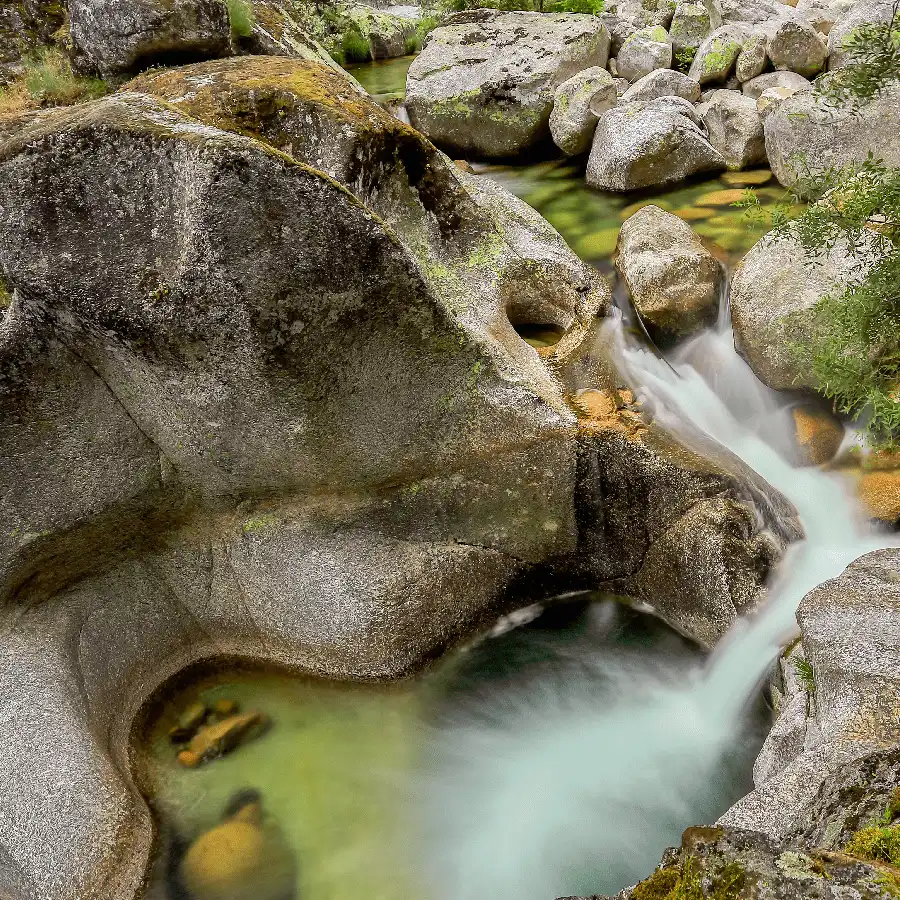Paisaje montañoso con río, refugio de paz y belleza natural en la Serra da Estrela.