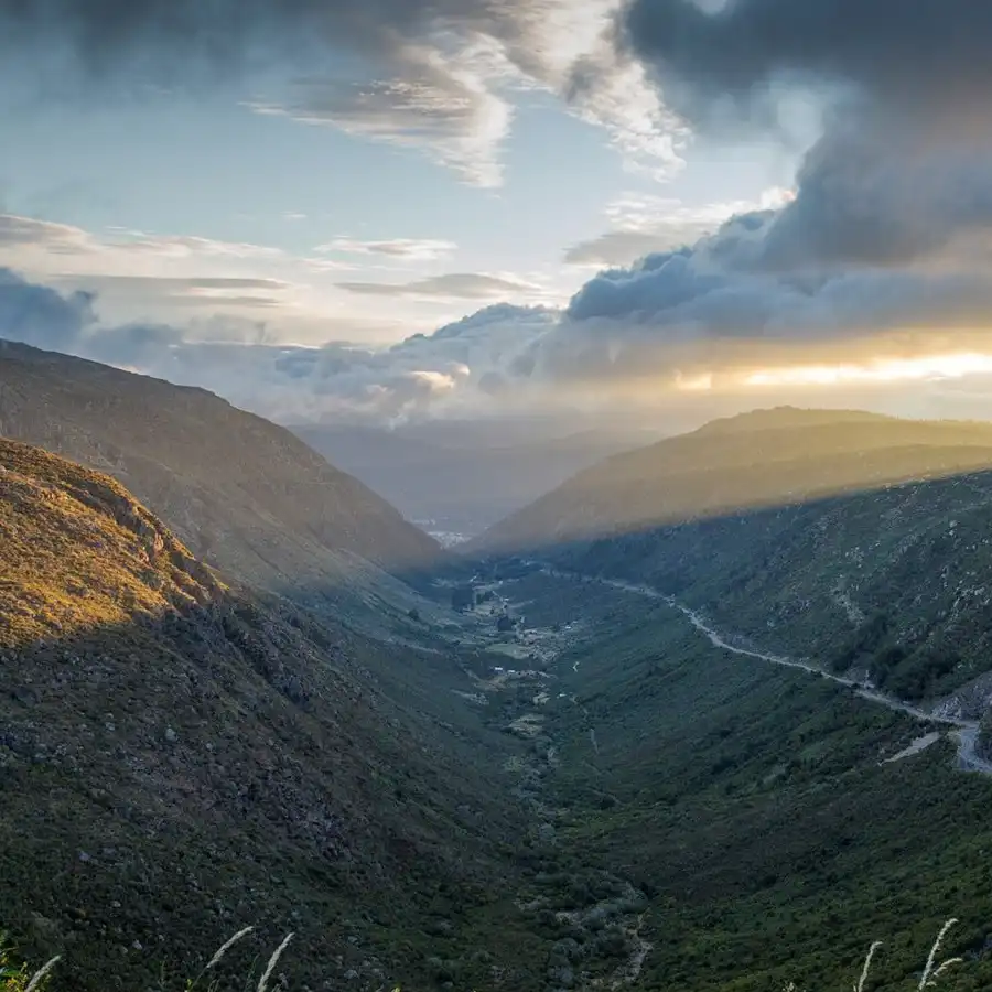 Valle serrano bañado por la luz dorada del amanecer o atardecer.