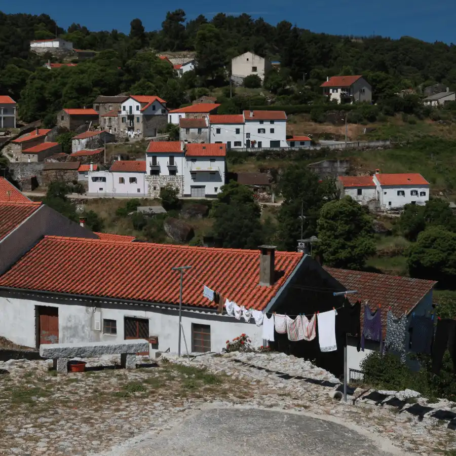 Pueblo serrano de encanto, con tejados de teja y vistas a la montaña.