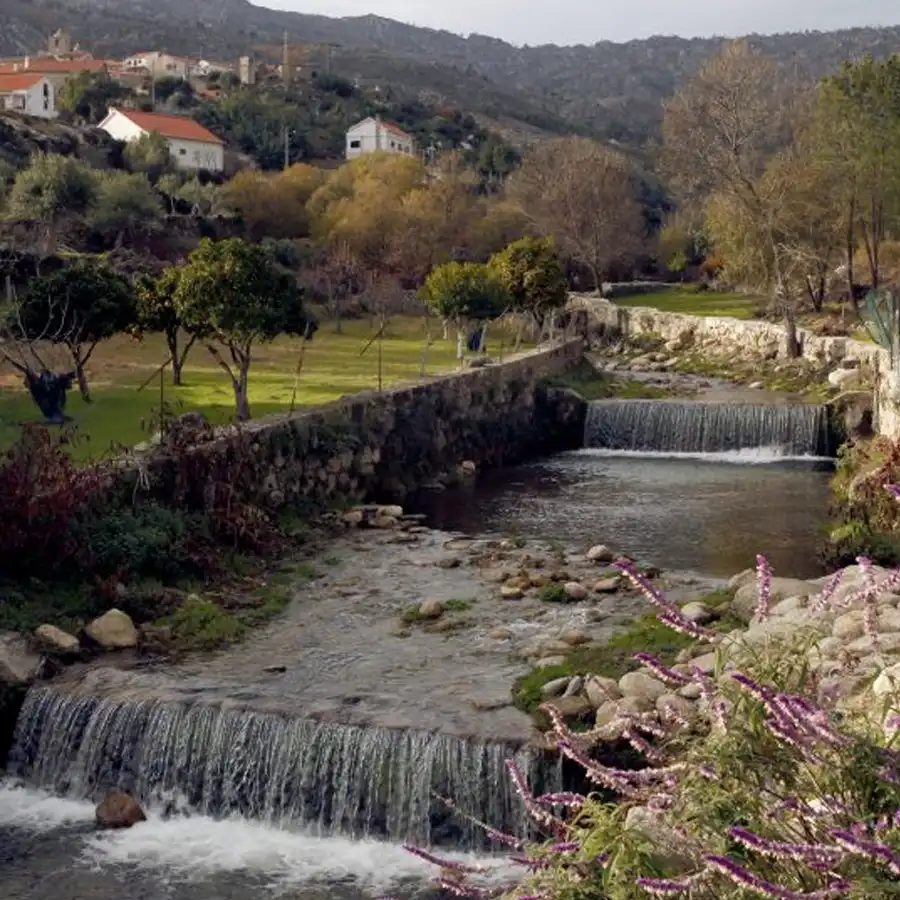 Arroyo serpenteante entre rocas y antiguas construcciones rurales en la Serra da Estrela.