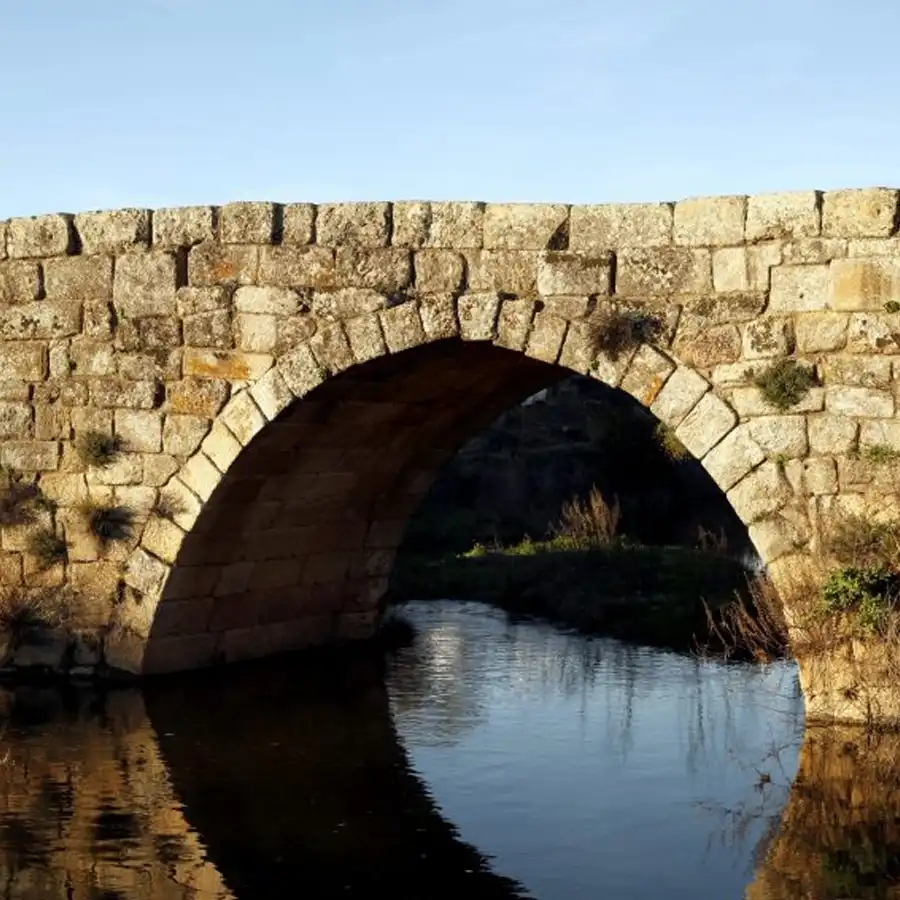 Puente de piedra centenario en un paisaje sereno de la Serra da Estrela.