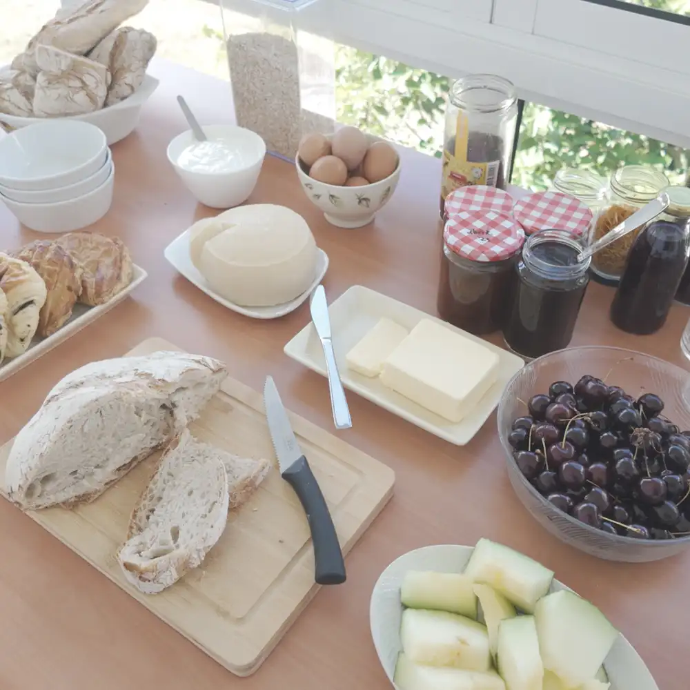 Bocado campestre: pan, fruta, queso y mermeladas para disfrutar al aire libre.