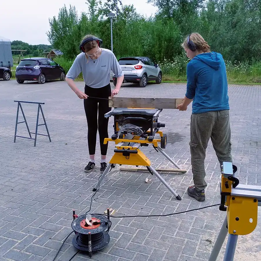 Artesanos trabajando en equipo, elaborando piezas de madera en un entorno rural.