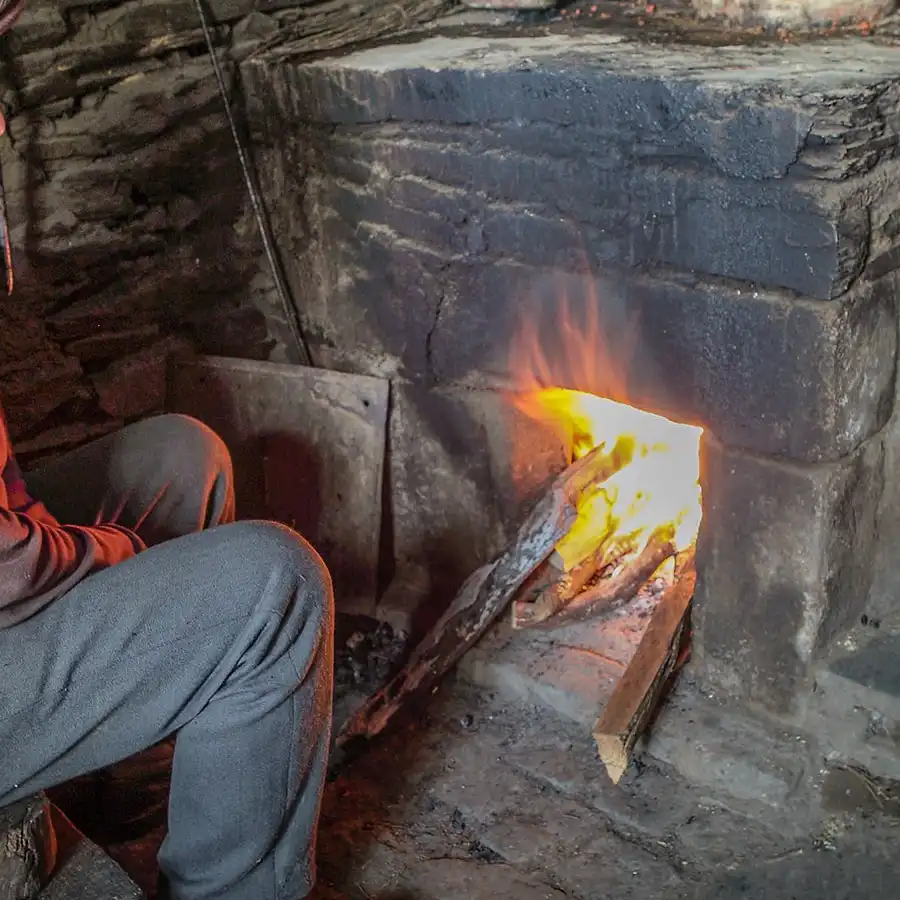 Gezelligheid bij de haard: traditioneel koken in een rustieke omgeving.