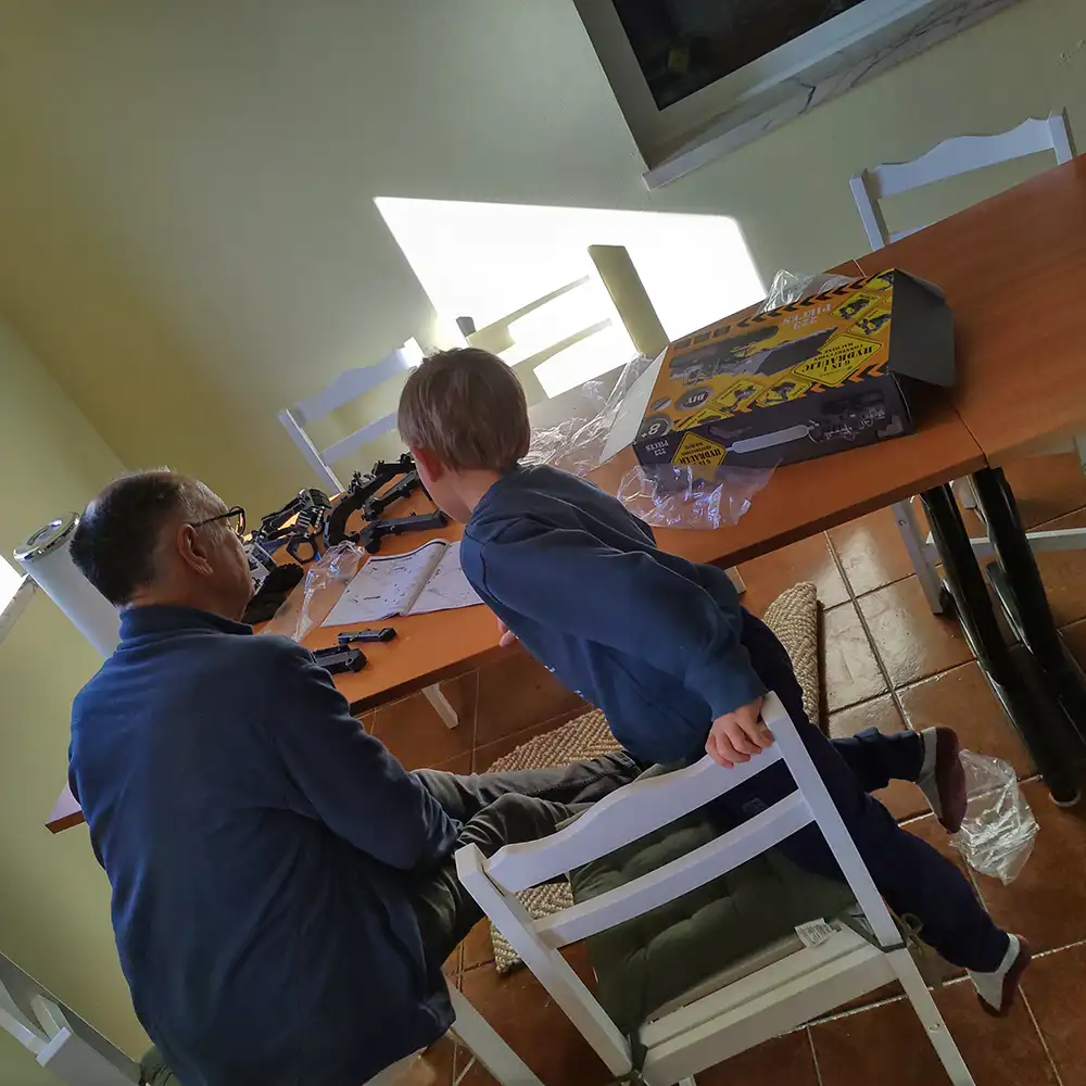 Adultos a colaborar num projeto artesanal numa acolhedora casa de montanha.